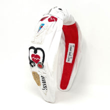 Load image into Gallery viewer, Whimsical medical-themed headband featuring embroidered nurse details and colorful embellishments.