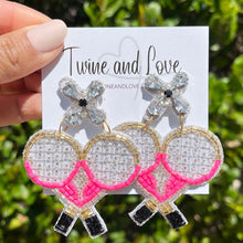 Load image into Gallery viewer, Model showcasing a pink pearl headband and beaded tennis racket earrings, paired with a black ruffle neckline top against a vibrant artistic backdrop.