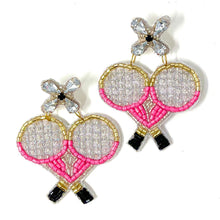 Load image into Gallery viewer, Close-up of a woman wearing handcrafted pink tennis racket earrings and a pearl-adorned pink headband, styled with an elegant black dress.