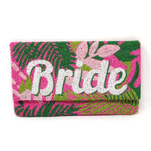 Load image into Gallery viewer, Woman holding a colorful hand-beaded clutch featuring the word “Bride” in white beads with tropical pink and green leaf designs.
