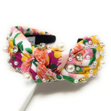 Load image into Gallery viewer, Fashion model in a vibrant floral jeweled headband and white daisy-inspired statement earrings in natural sunlight.